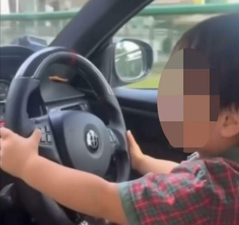 父让儿坐腿上“开车” 母在旁拍视频